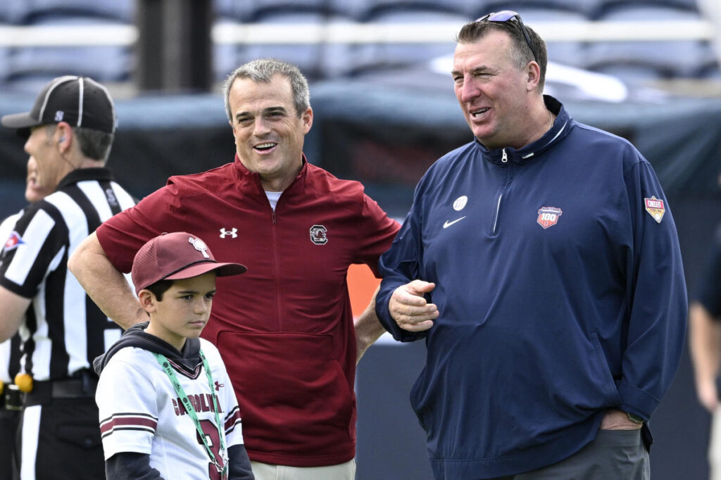 South Carolina coach Shane Beamer has to be restrained after Illinois’ Bret Bielema taunts USC sideline with substitution gesture