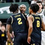 Michigan, Michigan State players shove one another at center court late in game